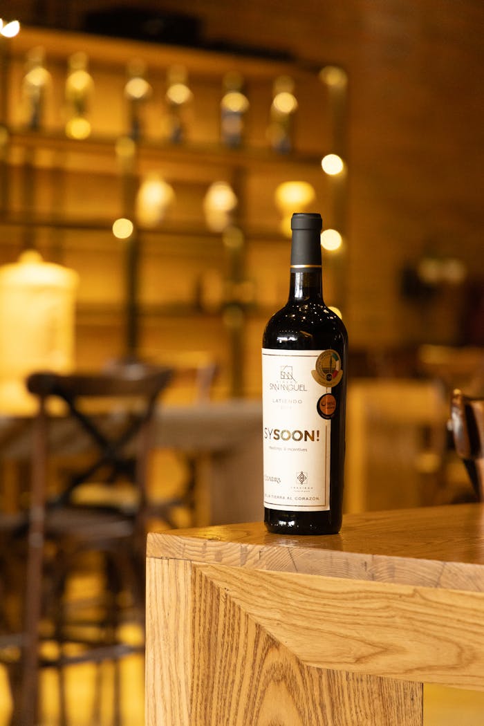 our-story Elegant red wine bottle on a wooden table, perfect for a luxurious dining ambiance.
