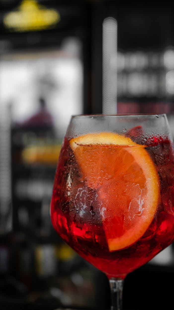 services-03 Close-up of a vibrant Aperol Spritz cocktail with orange slice in a glass, highlighting its refreshing appeal.